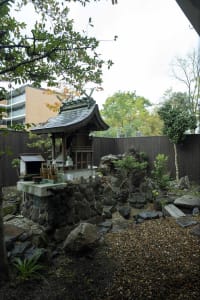 Traditional Japanese courtyard with a stone altar and surrounding rocks and plants