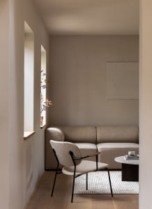 Modern minimalist living room with beige furniture and a round coffee table.