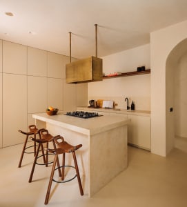 A minimalist residential kitchen featuring concrete and wooden elements.