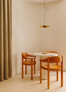 Modern residential space featuring a round, white table with wooden chairs.