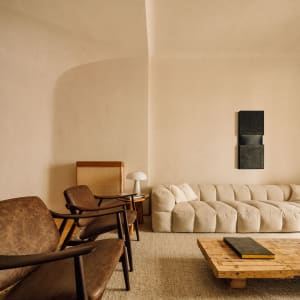 A textured living room featuring a comfortable sofa with neutral tones and a wooden coffee table.