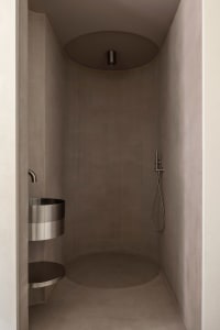 Modern bathroom with concrete walls and floor, minimalist design.