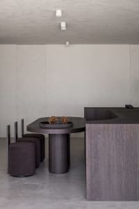 Modern minimalist dining space featuring wood and concrete materials and design.