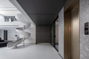 Modern playroom featuring a sleek, metallic slide and white floor tiles.