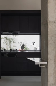 Modern industrial kitchen with black cabinets and metallic accents