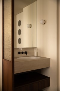 Modern, industrial-style bathroom featuring a minimalist design with a concrete sink.
