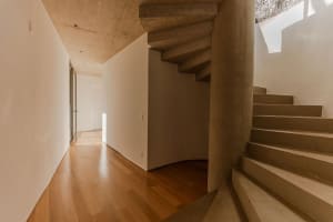 Modern industrial house featuring concrete staircase with natural light.
