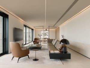 Modern living room with leather sofas, glass coffee table, and wooden accents.