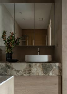 Modern minimalist bathroom with a marble countertop, sink, and mirror cabinet.