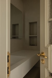 A modern bathroom with concrete walls and a built-in vanity.