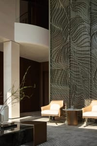 Modern industrial lobby featuring metallic patterns, concrete walls, and contemporary furniture.