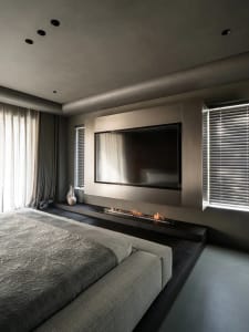 A modern bedroom featuring metallic elements and a large flat-screen television.