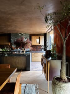 Modern residential kitchen featuring a marble countertop and wooden cabinets.