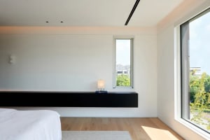 Modern bedroom with wooden flooring and minimalistic design.