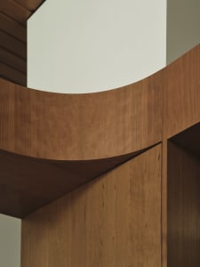 A modern interior design featuring wooden cabinets with curved edges.