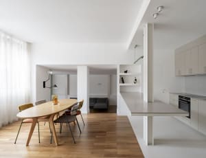 A modern residential kitchen with white cabinets and minimalist design features.