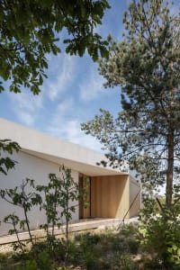 Modern residential house with white rendered exterior and concrete construction.
