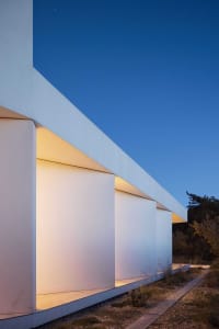 A modern house with a white exterior and concrete finish.
