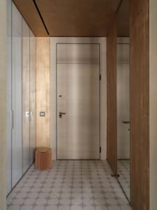 A modern interior design featuring a metallic doorway with a minimalist aesthetic and neutral colors.