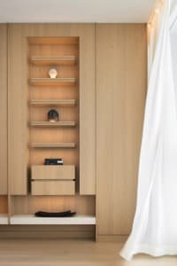 Modern living room with wooden entertainment center featuring built-in shelves and drawers.