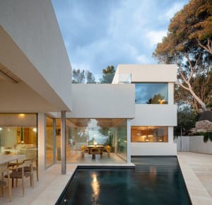 Modern residential architecture featuring glass walls and minimalist design elements.