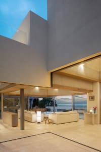 Modern living room featuring concrete elements and a view of the ocean.