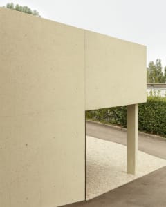 A modern, minimalist building made of concrete with a flat roof.