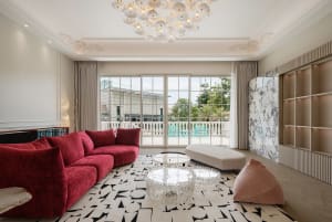 Modern living room with velvet cushions, marble coffee table, and patterned rug