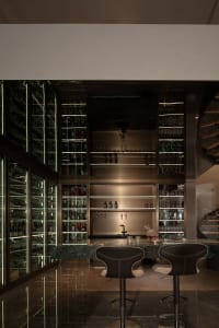 Minimalist design bar with glass shelves and bottles.