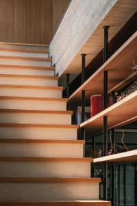 A modern staircase made of wood and concrete materials.