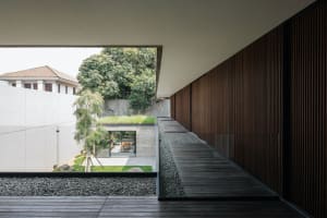 Modern patio featuring concrete, glass, and wooden elements.