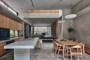 A modern residential kitchen featuring a concrete and wood interior design.