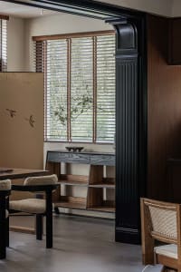 Modern black interior design with wood finishes, featuring minimalist furniture and plants.