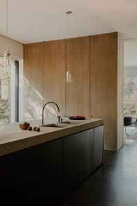 Modern minimalist kitchen featuring a concrete countertop with a built-in sink.
