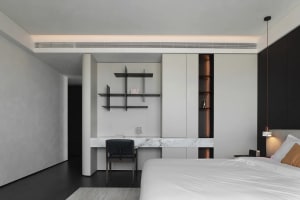 Modern bedroom featuring white marble floors and walls, minimalist design, and white bedding.