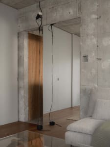 An industrial-style interior with a concrete wall and minimalist lighting.