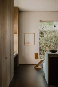 A minimalist residential kitchen featuring wood and concrete materials.