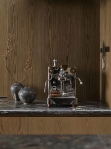 A sleek, modern kitchen featuring metallic appliances, wooden accents, and marble countertops.