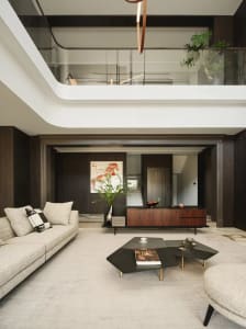 Modern living room featuring fabric furniture, wooden cabinets, and metallic accents.