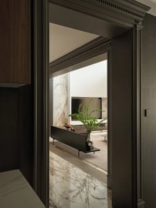 A modern minimalist living room featuring marble flooring and wooden furniture.