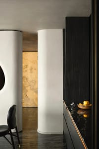 Modern residential entryway featuring marble flooring, dark wooden accents, and glass elements.