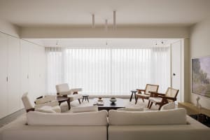 Modern living room with neutral-toned furniture and a large window.