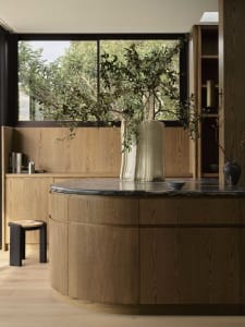 Modern residential interior featuring an elegant oak cabinet and a large white vase with a green plant, set against a backdro