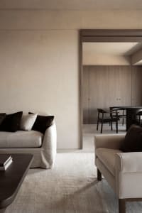 A neutral-toned living room with minimalist furniture and earthy color palette.