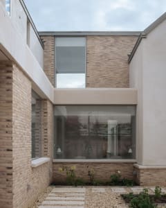 Modern house with brick exterior and large windows.