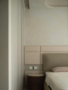 Modern minimalist bedroom showcasing wall paneling and floor plan details.
