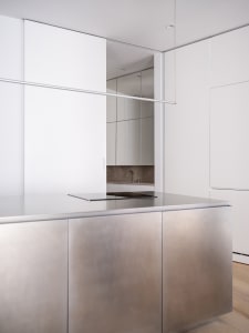Modern, white and stainless steel kitchen with minimalist design elements.