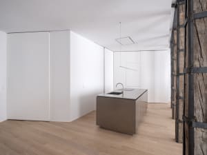 A modern kitchen featuring a minimalist design with a steel countertop.