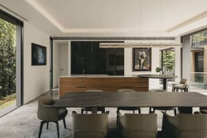 Modern residential interior featuring an open-plan living, dining, and kitchen area with marble countertops, wooden cabinets,