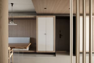 Modern minimalist kitchen with wooden cabinets, bench seating, and sleek design.
